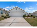 Two car garage with concrete driveway and mature landscaping at 1112 Jasmine Creek Ct, Sun City Center, FL 33573