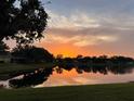 Scenic pond reflects a vibrant sunset over the neighborhood homes with mature trees at 11457 Captiva Kay Dr, Riverview, FL 33569