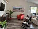 Cozy living room showcasing neutral walls, coastal artwork, and comfortable seating arrangement at 1165 Falcon Dr, Dunedin, FL 34698