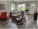 Inviting living room featuring wood floors, a comfortable sofa, and a decorative rocking chair at 1165 Falcon Dr, Dunedin, FL 34698