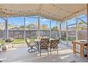Relaxing screened patio complete with comfortable seating, dining area, string lights and outdoor grill at 11808 Lancashire Dr, Tampa, FL 33626