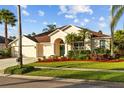 Well-maintained single-story home boasts a lush green lawn, a three-car garage, and an appealing, arched front entrance at 11906 Middlebury Dr, Tampa, FL 33626