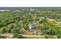 Aerial view of a home nestled amidst lush greenery and a serene pond in a rural setting at 1226 Debuel Rd, Lutz, FL 33549
