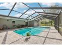 Enclosed pool area with brick pavers and a view of the yard at 1226 Debuel Rd, Lutz, FL 33549