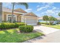 Beautiful home featuring lush green grass, landscaping and a brick paver driveway leading to the attached garage at 1231 Corinth Greens Dr, Sun City Center, FL 33573