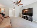 Bright living room featuring neutral walls, ceiling fan, and a large entertainment center at 1241 N Mcmullen Booth Rd, Clearwater, FL 33759