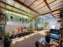 Covered patio with a variety of plants, outdoor furniture, and filtered sunlight at 1241 N Mcmullen Booth Rd, Clearwater, FL 33759