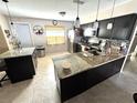 Updated kitchen showcasing an island, dark cabinets, granite countertops, and stainless steel appliances at 13924 Pathfinder Dr, Tampa, FL 33625