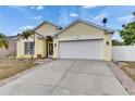 Home featuring a well-manicured lawn, palm trees, a driveway, and a two-car garage at 221 Lakeway Ln, Apollo Beach, FL 33572