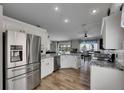 Open-concept kitchen features stainless steel appliances, white cabinetry, granite countertops, and an eat-in dining area at 221 Lakeway Ln, Apollo Beach, FL 33572