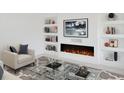 Stylish living room with modern decor, a cozy armchair, and a sleek fireplace at 2528 Columbus S Way, St Petersburg, FL 33712