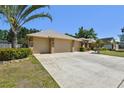 Spacious three-car garage with an extra wide driveway surrounded by manicured landscaping at 2914 Timber Knoll Dr, Valrico, FL 33596