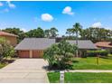 Spacious home with a three-car garage, a gray roof and beautiful landscaping at 3168 Masters Dr, Clearwater, FL 33761