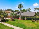 Beautiful home with well-manicured lawn, mature trees, and lush landscaping in a golf community at 3168 Masters Dr, Clearwater, FL 33761