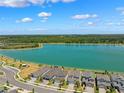 Stunning aerial view showcasing waterfront homes along a scenic lakefront community under a bright blue sky at 31779 Asbury Ave, Wesley Chapel, FL 33545