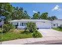 Charming single-story home featuring a well-manicured front yard with mature trees at 3408 90Th N Ter, Pinellas Park, FL 33782
