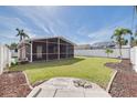 Spacious backyard featuring a screened-in patio, lush green lawn, and a partial view of surrounding properties at 3516 Casablanca Ave, St Pete Beach, FL 33706