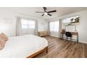 Bright bedroom with light wood floors, modern ceiling fan, and a TV above a stylish desk at 3981 Mckay Creek Dr, Largo, FL 33770