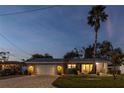 Inviting single-story home showcasing a brick driveway, garage, and lush landscaping at 3981 Mckay Creek Dr, Largo, FL 33770
