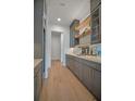 Gray butler pantry with lots of storage, granite countertop, and wood shelving at 4607 W Lamb Ave, Tampa, FL 33629
