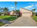 Charming home with lush lawn and mature landscaping leading to an attached two-car garage at 6104 Schooner Way, Tampa, FL 33615