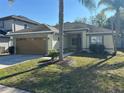 Attractive single-story home with a two-car garage, mature landscaping, and a welcoming facade at 7326 Cutwater Ln, Wesley Chapel, FL 33545
