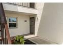 Front door with sidelight, unit number 445, and decorative plants at 7701 Starkey Rd # 445, Seminole, FL 33777