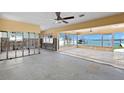 Large living area with waterfront views through oversized windows, perfect for entertaining at 844 Bay Point Dr, Madeira Beach, FL 33708