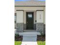 Charming home entrance featuring a dark-green front door with brick-base pillars at 930 57Th N Ave, St Petersburg, FL 33703