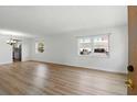 Bright living room featuring wood-look flooring and large windows offering plenty of natural light at 10035 63Rd N Ave # 12, St Petersburg, FL 33708