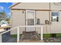 Rear exterior entrance featuring a ramp and access door with neutral siding at 103 146Th E Ave, Madeira Beach, FL 33708
