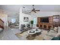 Bright living room with vaulted ceilings, ceiling fan, modern furnishings, and a built-in entertainment center at 10906 Kenbrook Dr, Riverview, FL 33578