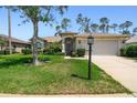 Charming single-story home featuring a well-maintained lawn and a welcoming two-car garage at 11147 Brambleleaf Way, Hudson, FL 34667