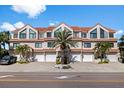 Charming townhome features multiple units, garages, tile roof, palm trees, and inviting curb appeal at 1206 Gulf Blvd # C, Indian Rocks Beach, FL 33785