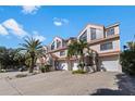 Inviting townhome boasts an attached garage and well-maintained landscaping with mature palm trees at 1206 Gulf Blvd # C, Indian Rocks Beach, FL 33785