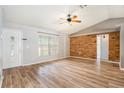 Bright living room with new wood flooring, a wood accent wall, vaulted ceilings, and lots of natural light at 12129 Meadow Ln, San Antonio, FL 33576