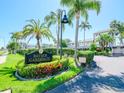 Bayside Gardens IV entrance featuring lush landscaping, mature palm trees, and well-maintained signage at 1301 Gulf Blvd # 107, Clearwater Beach, FL 33767