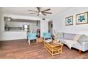 Bright open living room with stylish decor, hardwood flooring, and open access to an adjacent, modern, white kitchen at 1400 Pine Glen Ln # B2, Tarpon Springs, FL 34688