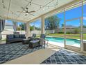 Screened outdoor living space with stylish furniture and view of the beautiful sparkling pool at 17311 Hubers Ct, Odessa, FL 33556