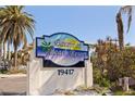 Welcome to Barefoot Beach Resort! The community sign includes its street number and a palm tree, under a bright blue sky at 19417 Gulf Blvd # E217, Indian Shores, FL 33785