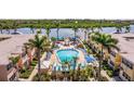 Relax by the beautiful pool with lounge chairs and umbrellas, surrounded by lush landscaping and charming buildings at 19417 Gulf Blvd # E217, Indian Shores, FL 33785