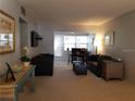 Bright living room featuring cozy furniture, carpet and a sliding door to the lanai at 1975 W Bay Dr # 207, Largo, FL 33770