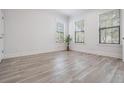 Bright bedroom with wood-look flooring, white walls, and lots of natural light from the multiple windows at 207 Chippewa Ave, Tampa, FL 33606