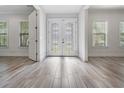 Bright foyer featuring decorative glass doors, wood look tile flooring, and white trim at 207 Chippewa Ave, Tampa, FL 33606