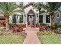 Inviting front entrance with double wood doors, red potted plants, and a brick walkway at 207 Chippewa Ave, Tampa, FL 33606