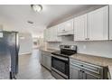 Modern kitchen with stainless steel appliances, granite countertops, and white and gray cabinetry at 3208 E 8Th Ave, Tampa, FL 33605