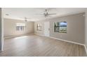 Bright living room with light-colored hardwood flooring, ceiling fans, and natural light streaming through the windows at 3208 E 8Th Ave, Tampa, FL 33605