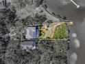 Aerial view of waterfront property with dock and gazebo; surrounding vegetation highlighted by white border at 3484 Shore Dr, Safety Harbor, FL 34695