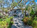 Stunning two-story home with a three-car garage and lush tropical landscaping at 3484 Shore Dr, Safety Harbor, FL 34695