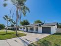 Inviting single-story home with a freshly painted exterior, attached garage, and a well-maintained front lawn at 352 79Th Ne Ave, St Petersburg, FL 33702
